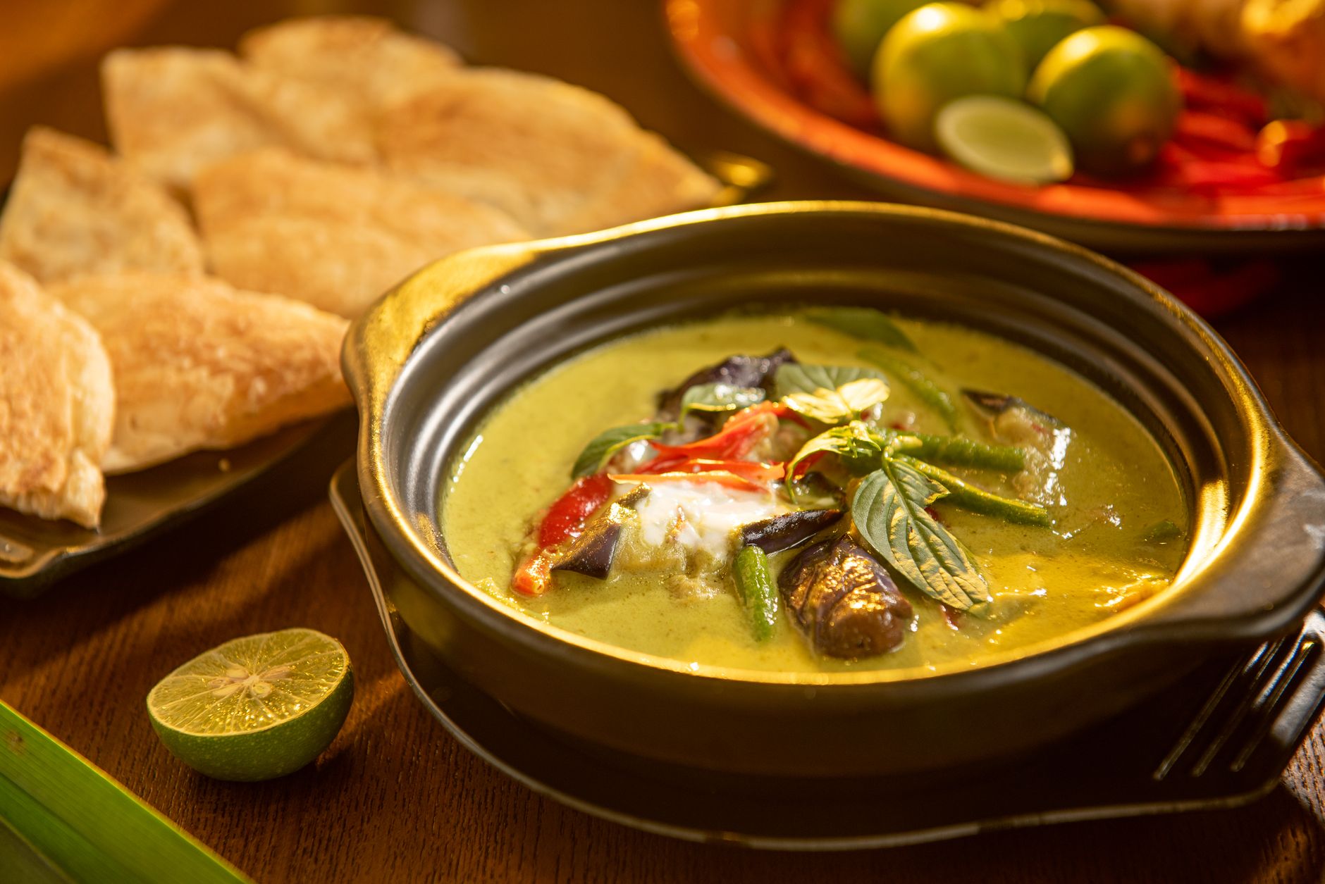 Bowl of Thai green curry with vegetables and herbs