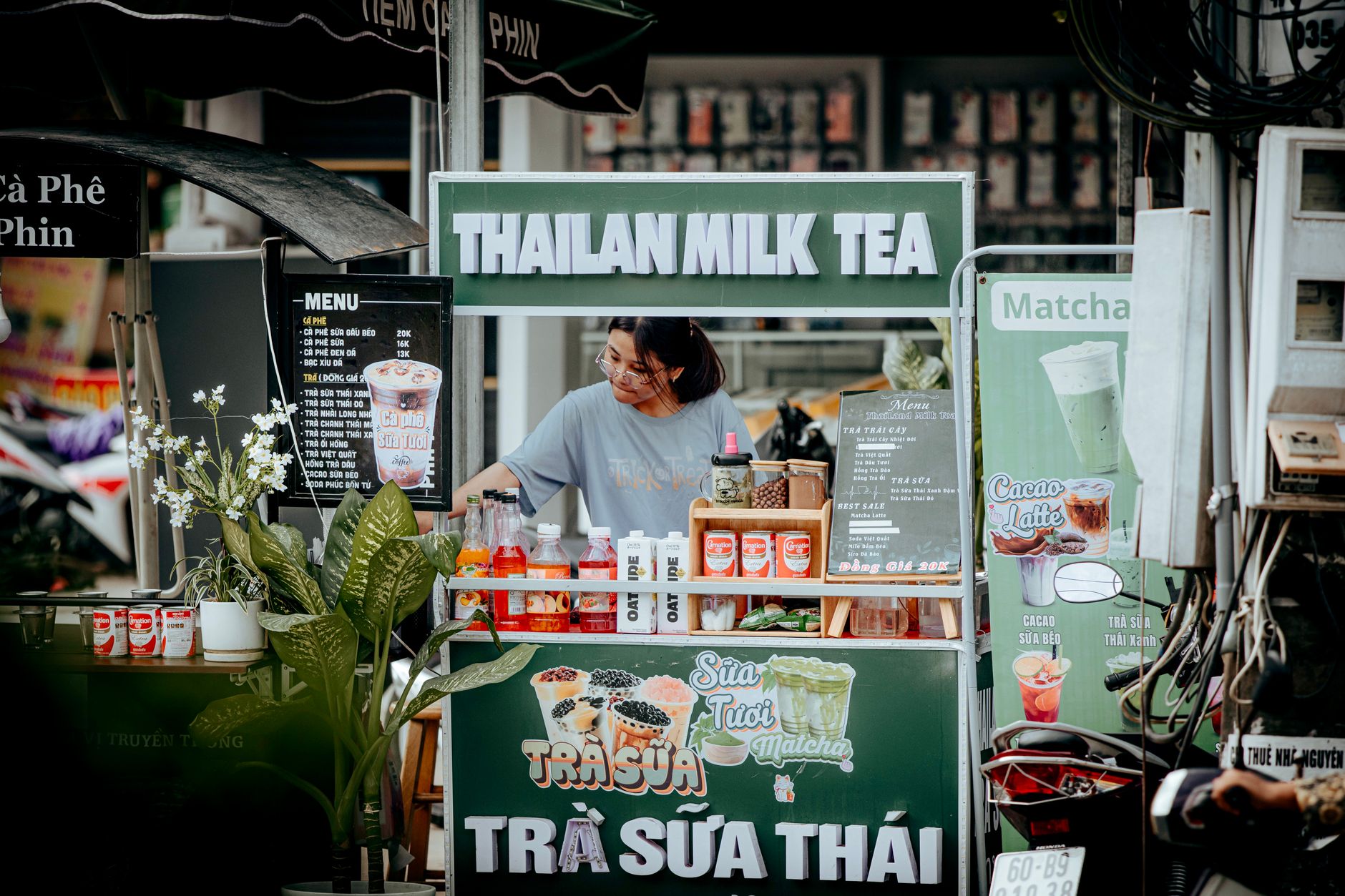 Street vendor pouring milk tea at a market stall