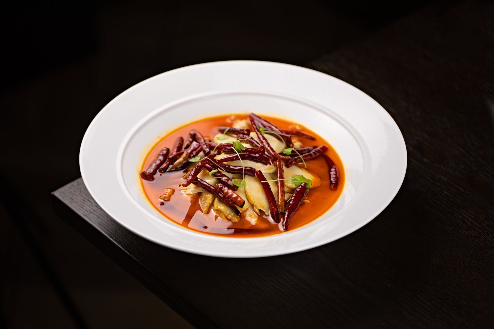 Bowl of spicy Asian soup garnished with chili flakes