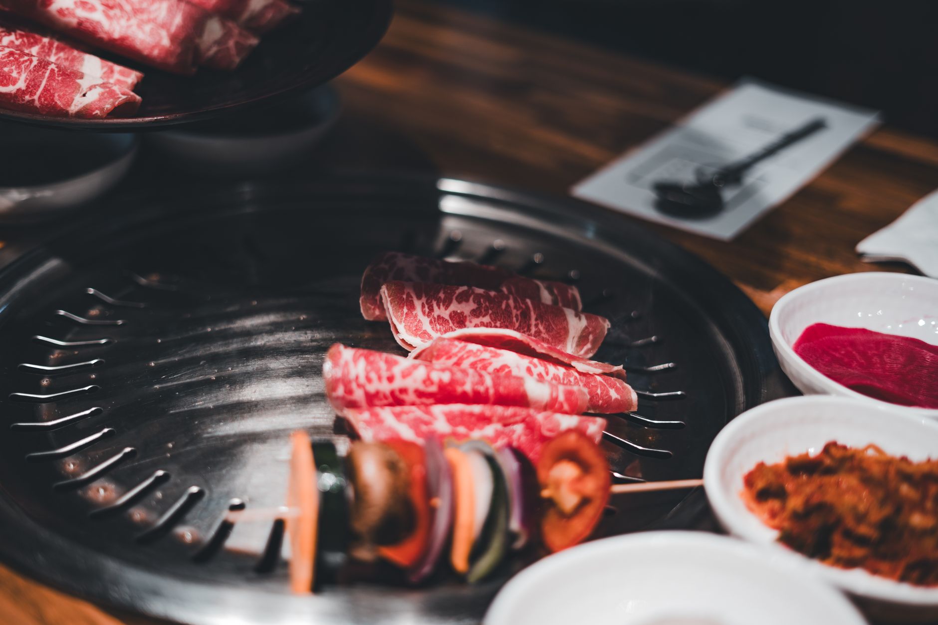 Korean BBQ with sliced beef and fresh vegetables grilling