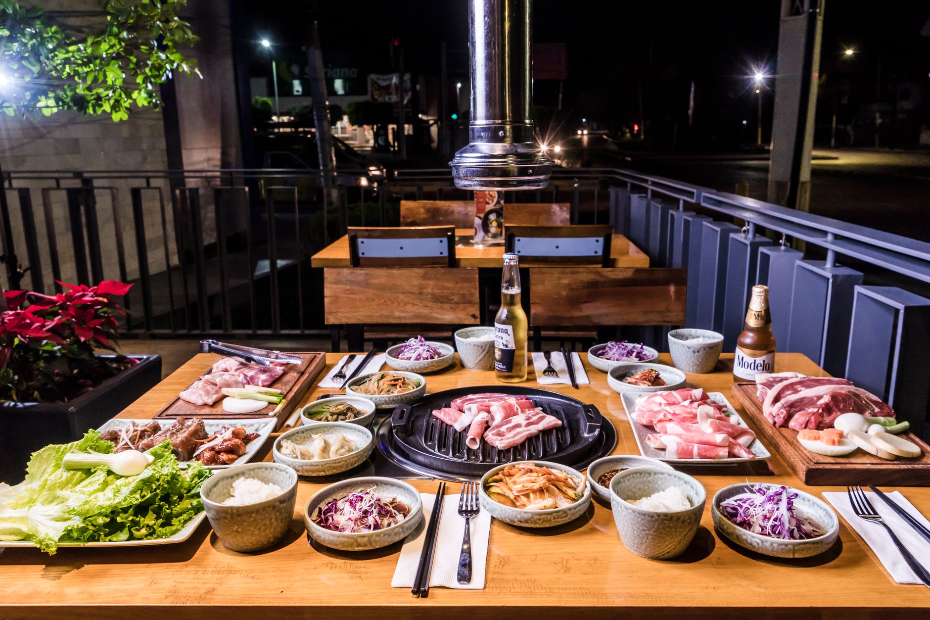 Korean BBQ spread of meats and vegetables on a restaurant grill table