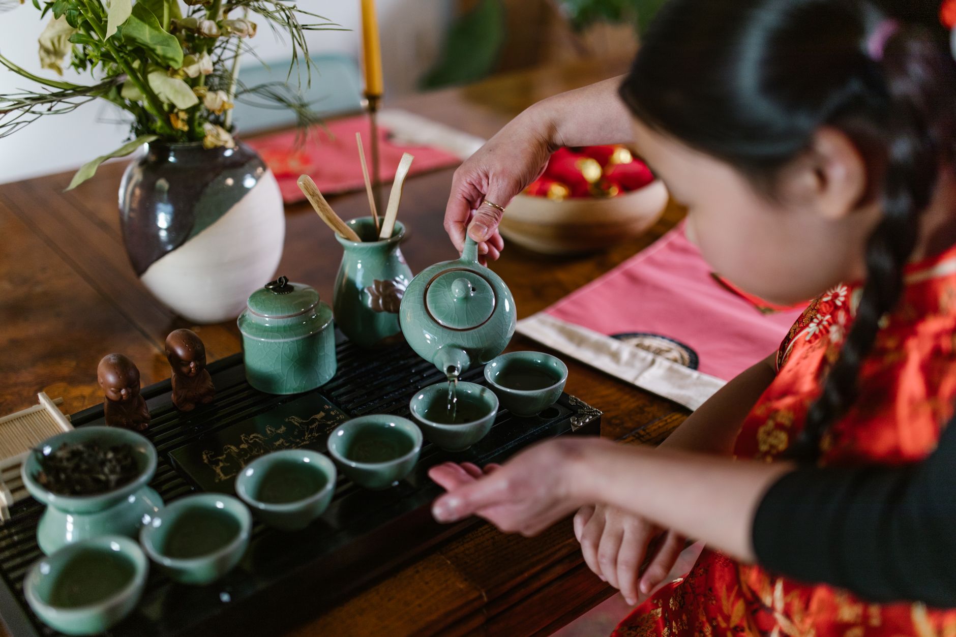 Pouring hot Chinese tea into a cup at a dim sum table