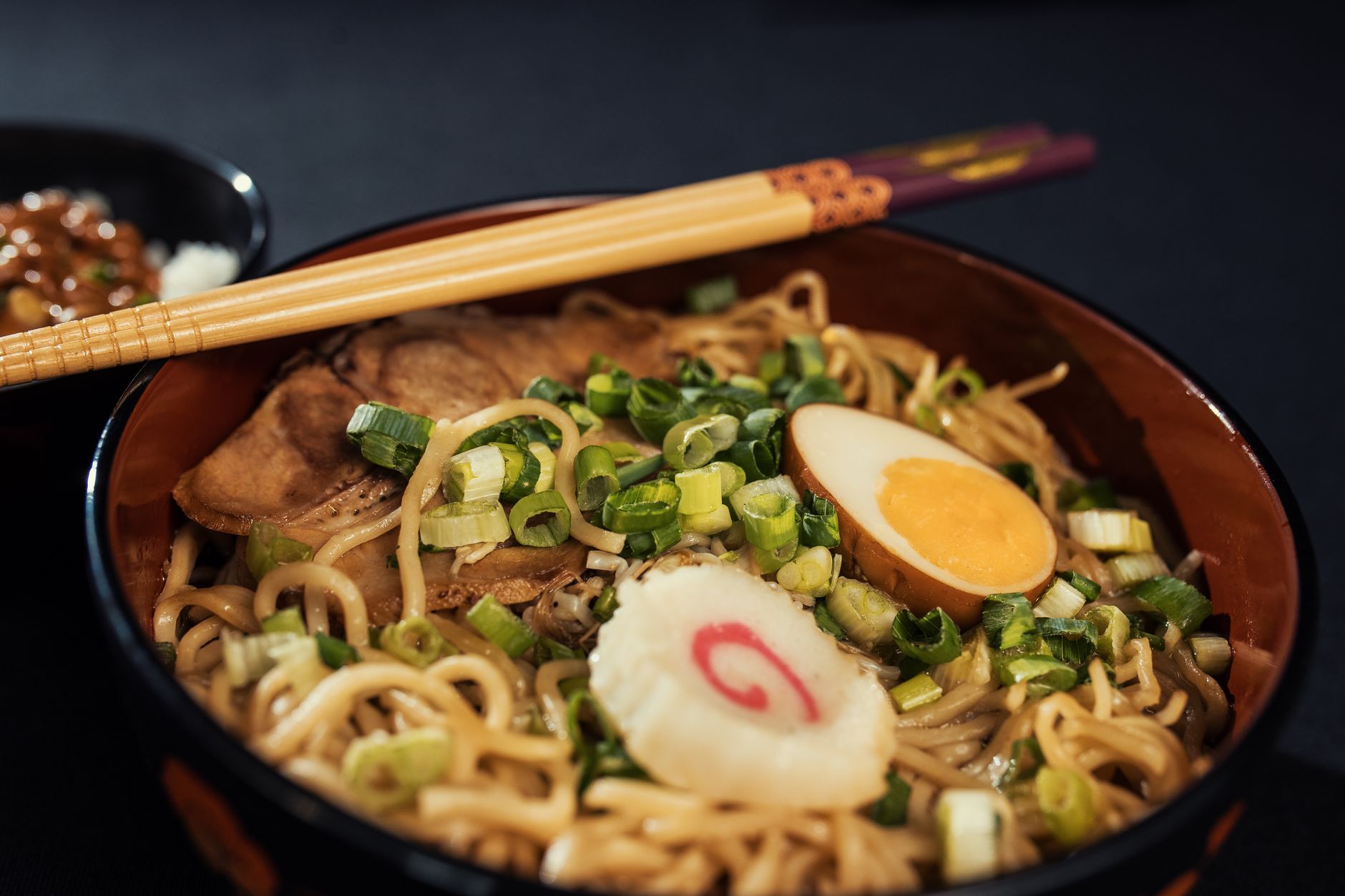Bowl of ramen with boiled egg, scallions, and narutomaki