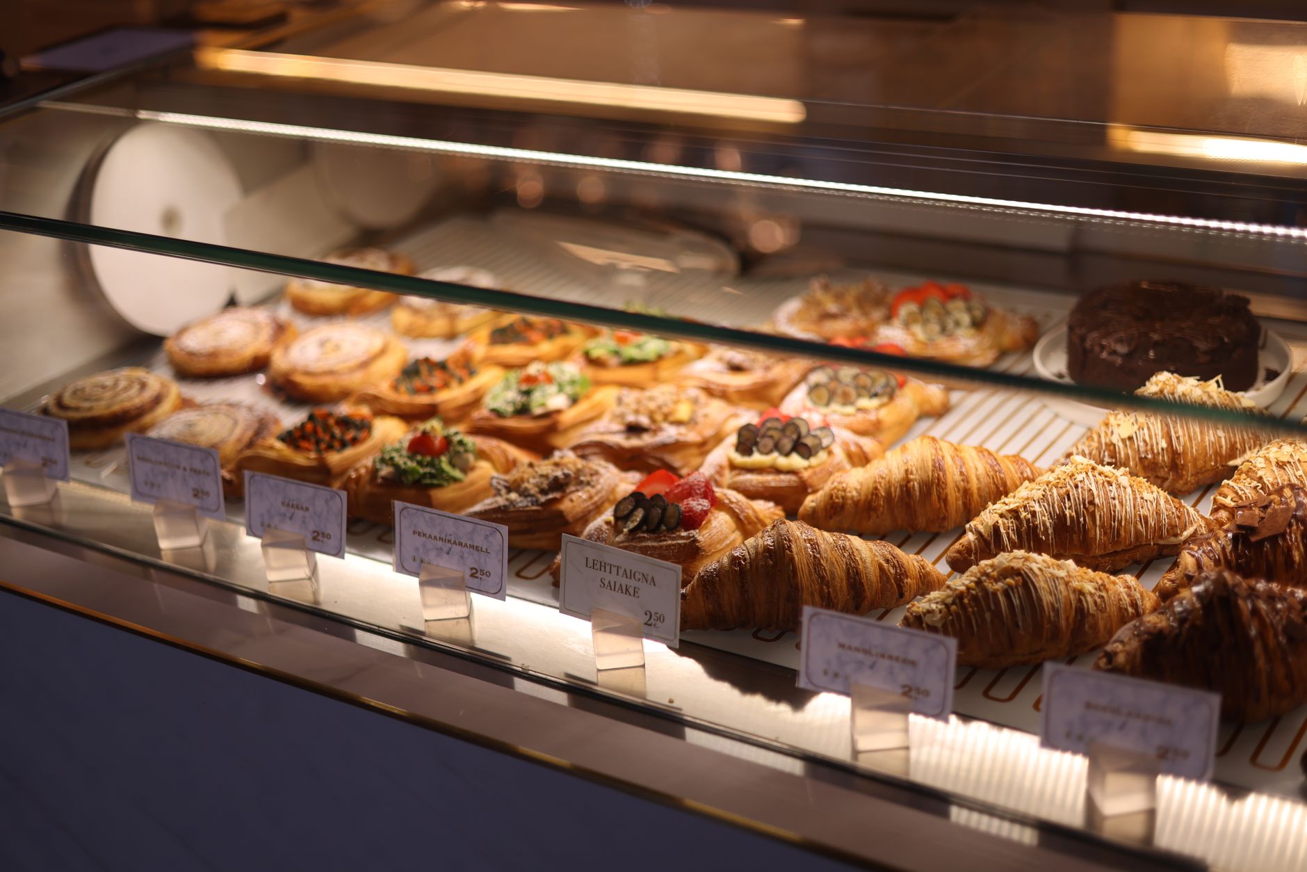 Assorted pastries and croissants in a bakery display case