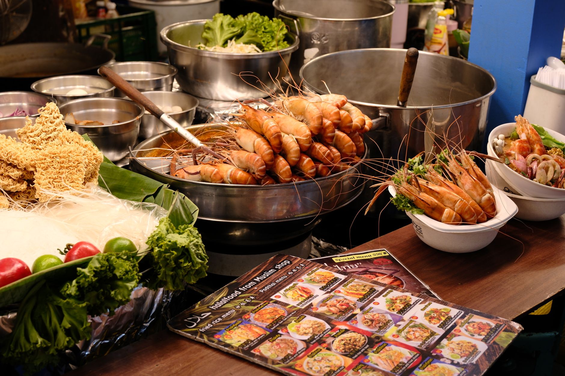 Vibrant Thai food display with prawns, noodles, and fresh produce