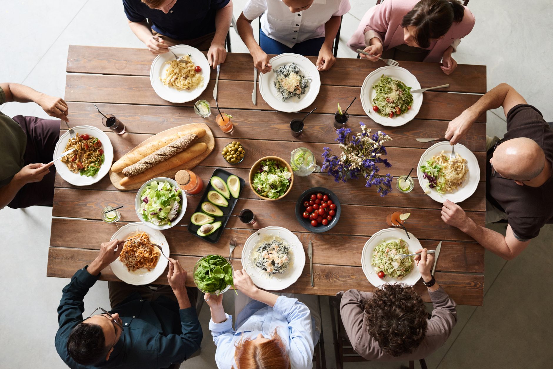 Group of adults sharing a family-style meal together at a table