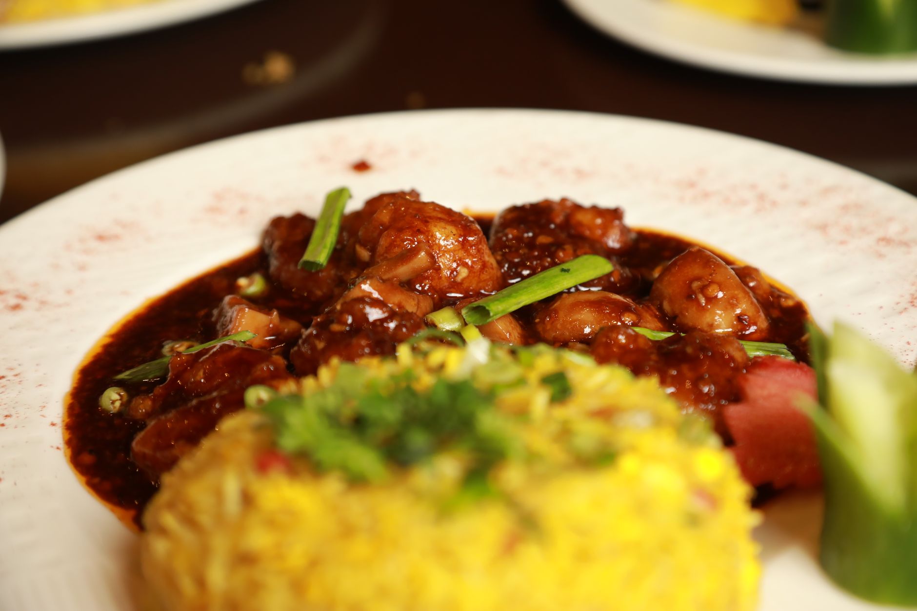 Saucy Chinese chicken dish served with fried rice, a typical dinner-portion entree